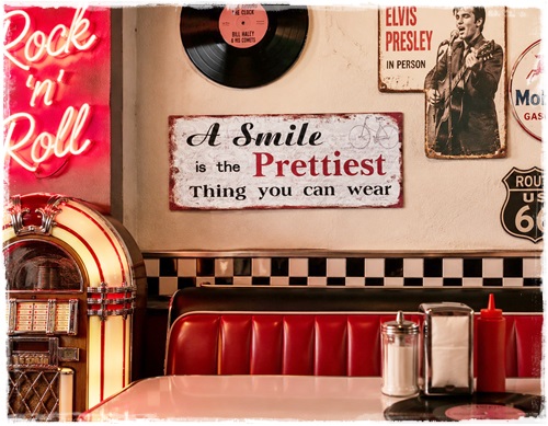 Tekstbord in zeer oude look, A smile is the prettiest thing you can wear. Afm. 50 x 20 cm.